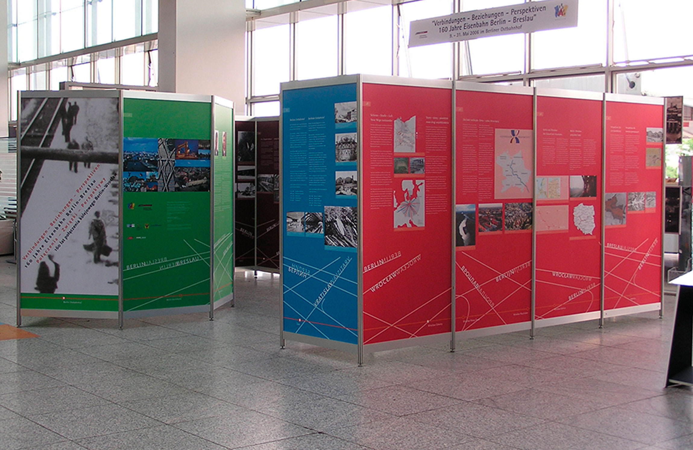 Octanorm Messetafeln in rot, blau und grün stehen nebeneinander in einem Ausstellungsraum.